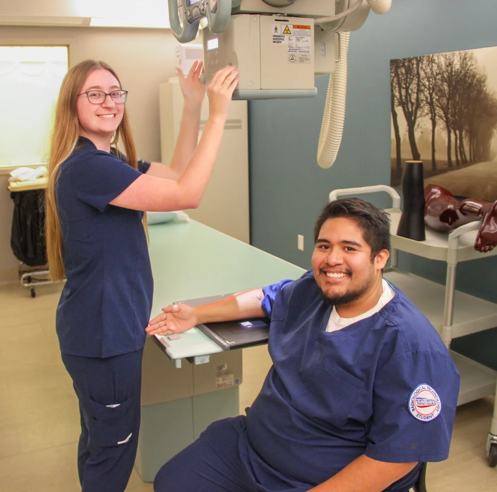 radiology students posing for photo while working with machine
